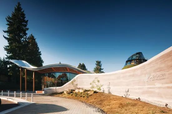 Rammed-earth walls line the path to the entrance and continue on the interior.