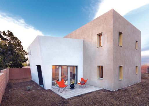 The one-story white cube contains the living room; its flat roof is finished as a deck for the second floor.