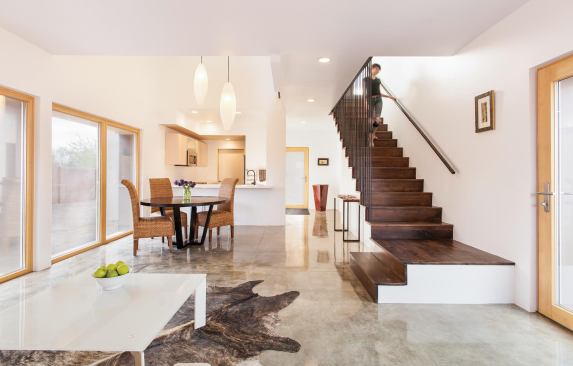 Strategically placed windows and glass walls admit plenty of light without compromising the thermal envelope. The compact floor plan features a small office at the top of the stairs.