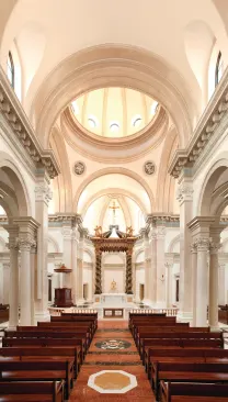 Laid out in a cruciform plan, the chapel interior boasts classical details carved by hand from marble and cast from plaster. A seven-arch colonnade—with Corinthian columns designed by Stroik and an entablature of faux blue marble—runs down either side of the nave, framing relief sculptures depicting the 14 Stations of the Cross in the side aisles. Light filters in through clerestory windows and oculi in the large Brunelleschi-esque dome that precedes the chapel's centerpiece: a 34-foot-tall baldachino inspired by Bernini's baroque masterpiece at St. Peter's in Rome.