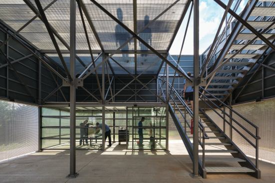 A second level in the open-air volume allows access to the rooftop photovoltaic array, which contributes to the building being 12 percent net positive.