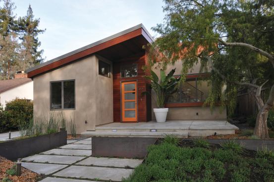 Clean lines and a simple palette of concrete and stucco helped modernize the front of the Schena-Ricke Residence, while the addition of a setback second story brought much-needed space without adding too much visual volume from the street. Cedar siding accents the entryway.