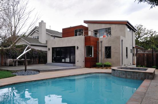 NanaWall opening glass walls connect the new family room (formerly the master bedroom) to the existing outdoor deck, patio, and pool, as well as the new second-floor master bedroom to a rear balcony.