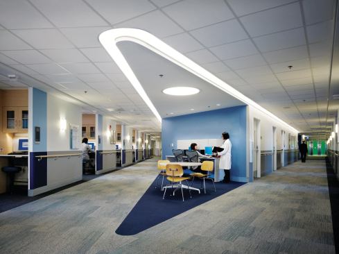 Nurses stations anchor each arm of the building’s patient-room floors. Cove lighting from Philips is inscribed into the ceiling to echo the overall building form.