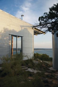 In keeping with the project's simple, elemental aesthetic, a halved steel pipe creates a gutter connecting the roof to the rainwater tank.