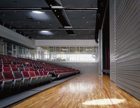 A mechanical system converts the gym into an auditorium with tiered seating in about a minute.