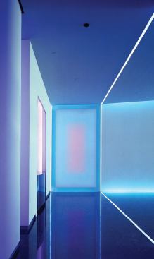 The final configuration is L-shaped, lit by color-changing LED light cabinets and cove lighting and cold-cathode tubes. 