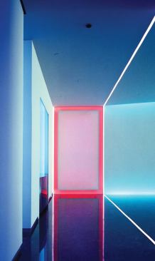 The view from the elevator lobby back toward the entrance lobby shows the dramatic effect of the lighting strategy and the shift in mood that accompanies a change in the colors of the light cabinets.