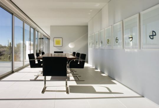Interior walls step back from the exterior envelope to leave the expanse of glass unbroken through the length of the house. 