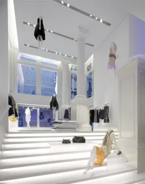 Custom extruded ceiling slots house mechanical systems and two multi-circuit tracks for controlling and hanging motorized theatrical equipment separately from AR111 spotlights. Fluorescent backlighting and translucent acrylic platforms allow the stair to double as display.