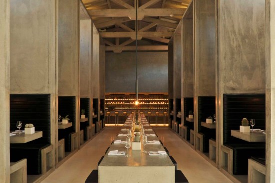 The dining room’s centerpiece— a large communal dining table— juxtaposes
the space’s verticality, while large monolithic concrete booths provide
a more intimate dining setting.